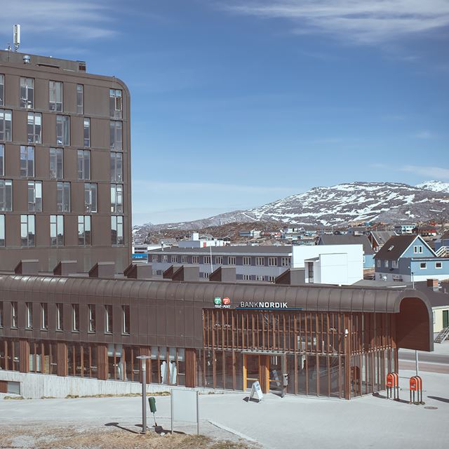 filialen Nuuk med et bjerg i baggrunden.